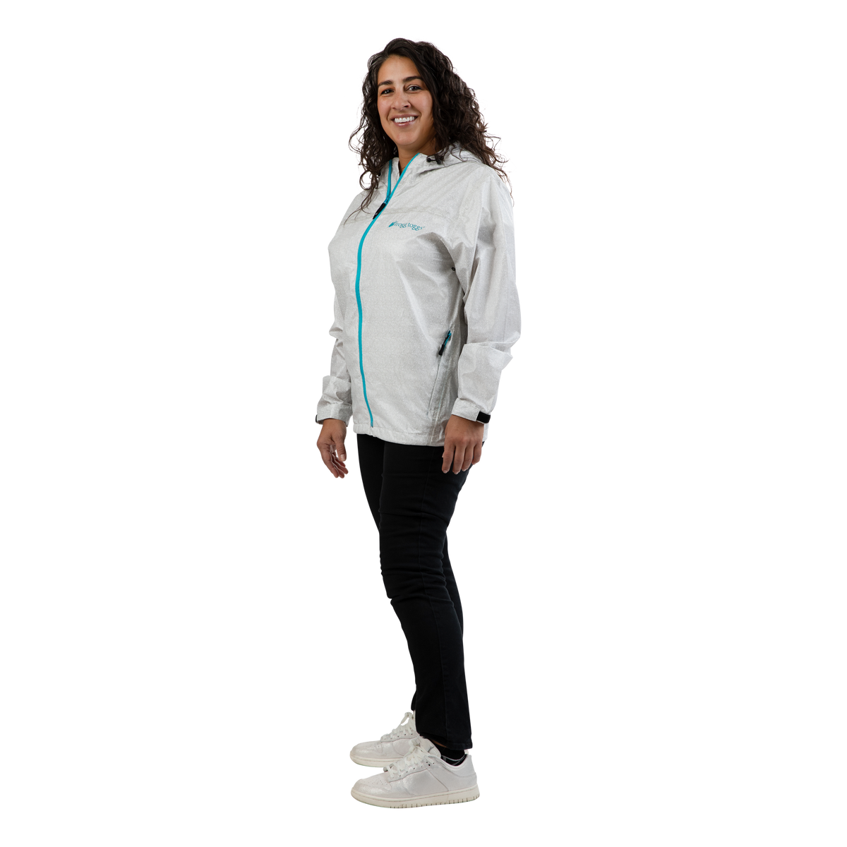 A woman modeling a light gray hooded windbreaker jacket with a bright turquoise zipper, paired with black pants and white sneakers, shown against a solid white background.