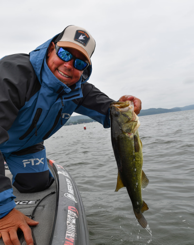Chris Lane presenting a freshly caught large mouth bass. Chris’s favorite frogg toggs gear is the FTX Elite Jacket and Bib.