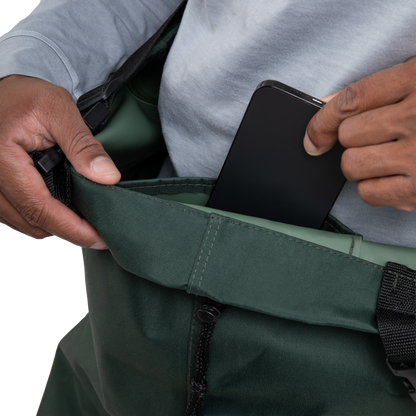 Person placing a black phone into a green bag