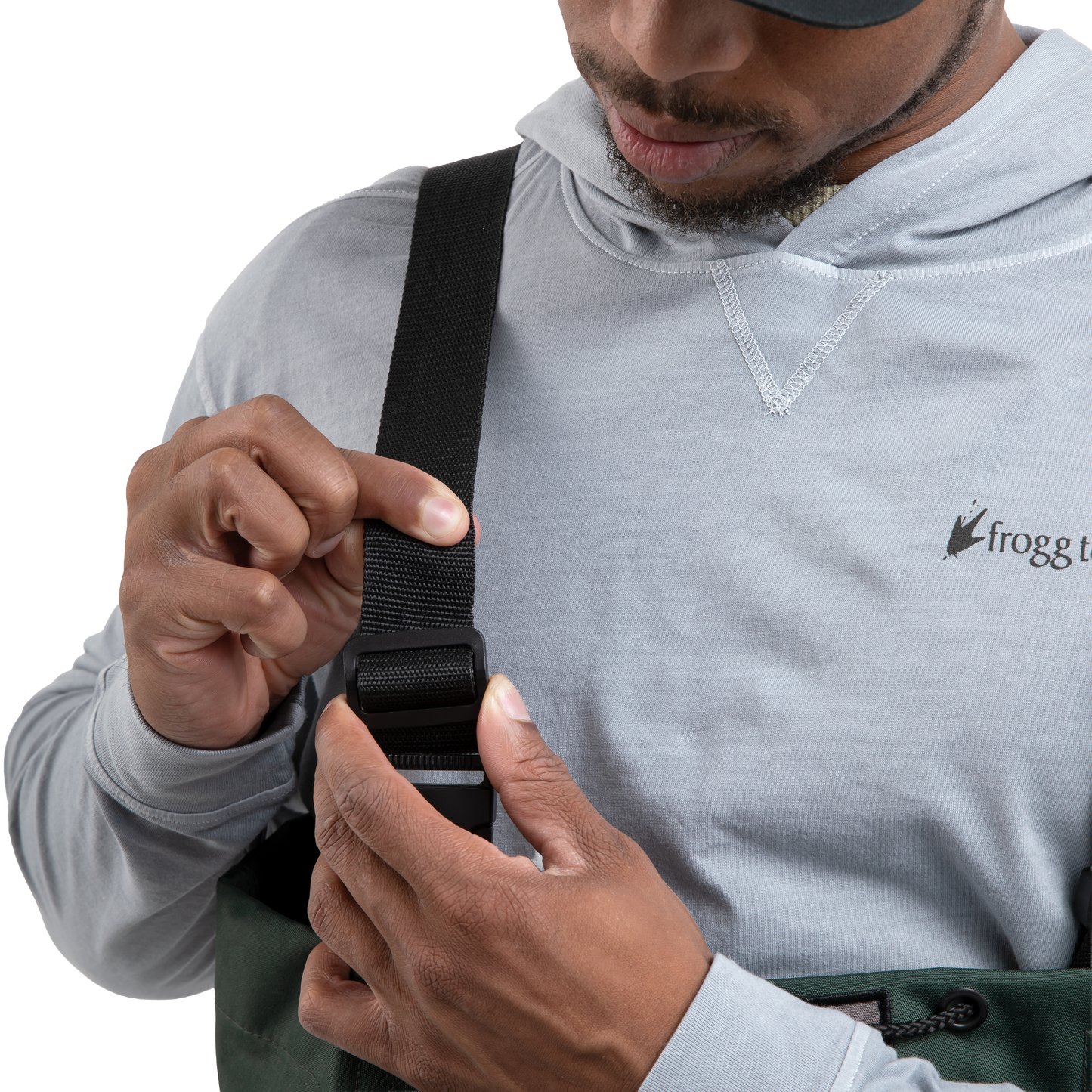 Person adjusting a strap on a bag, wearing a gray hoodie with a brand logo.