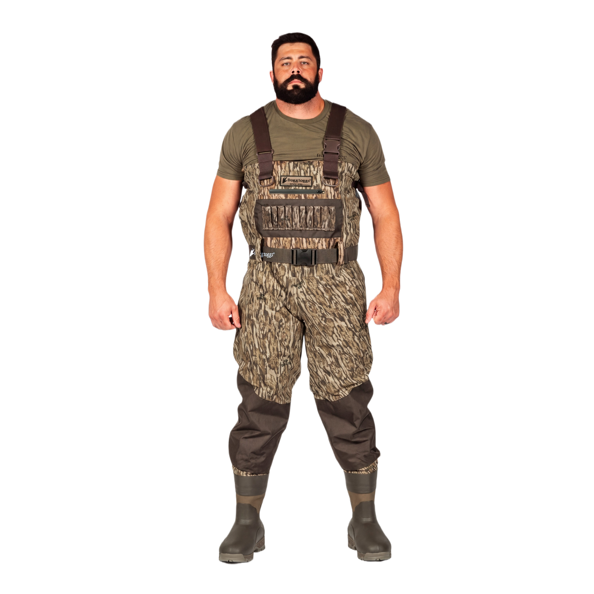 A man modeling a pair of camouflage chest waders with brown suspenders, an olive green t-shirt, and dark rubber boots, set against a plain white background.