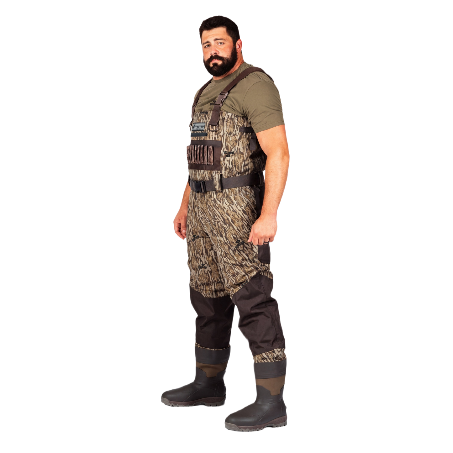A man wearing a pair of camouflage chest waders over an olive green t-shirt and black rubber boots, standing against a solid white background.