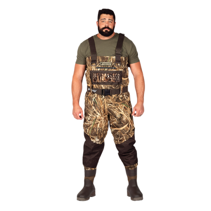 A man modeling a pair of camouflage duck waders over an olive green t-shirt and dark brown rubber boots, standing against a solid white background.