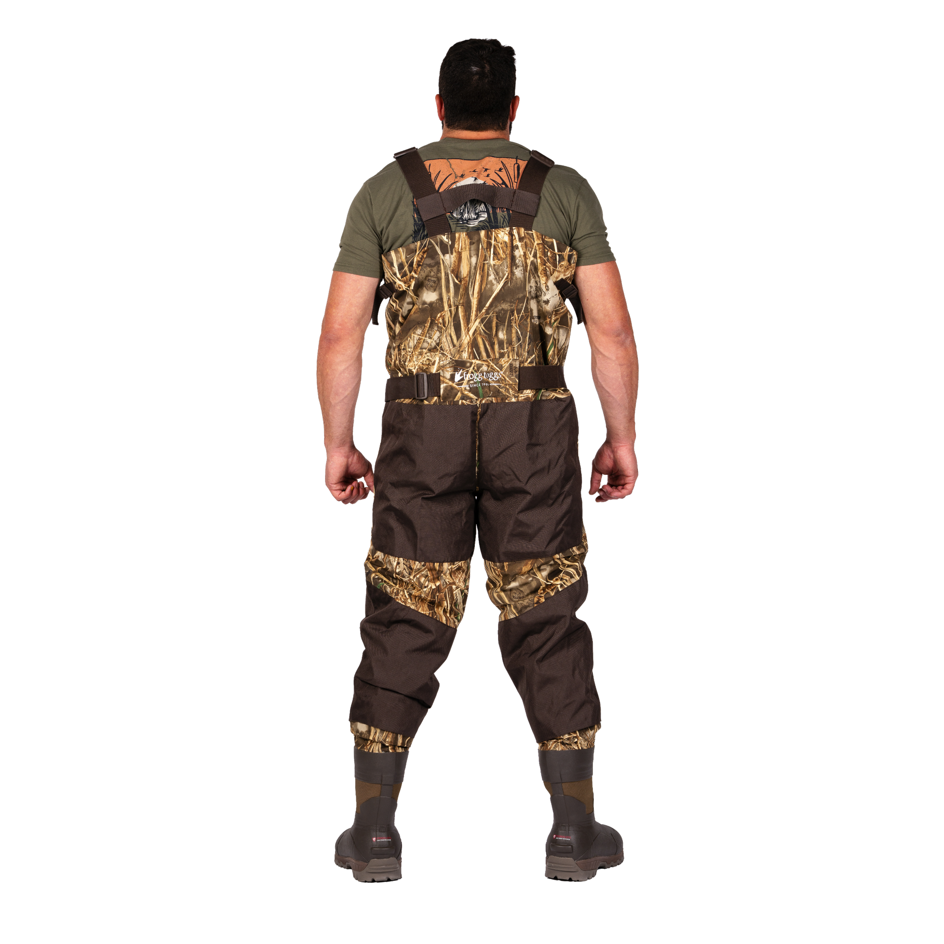 A man viewed from the back wearing a pair of camouflage and brown waders over an olive green t-shirt, standing against a solid white background.