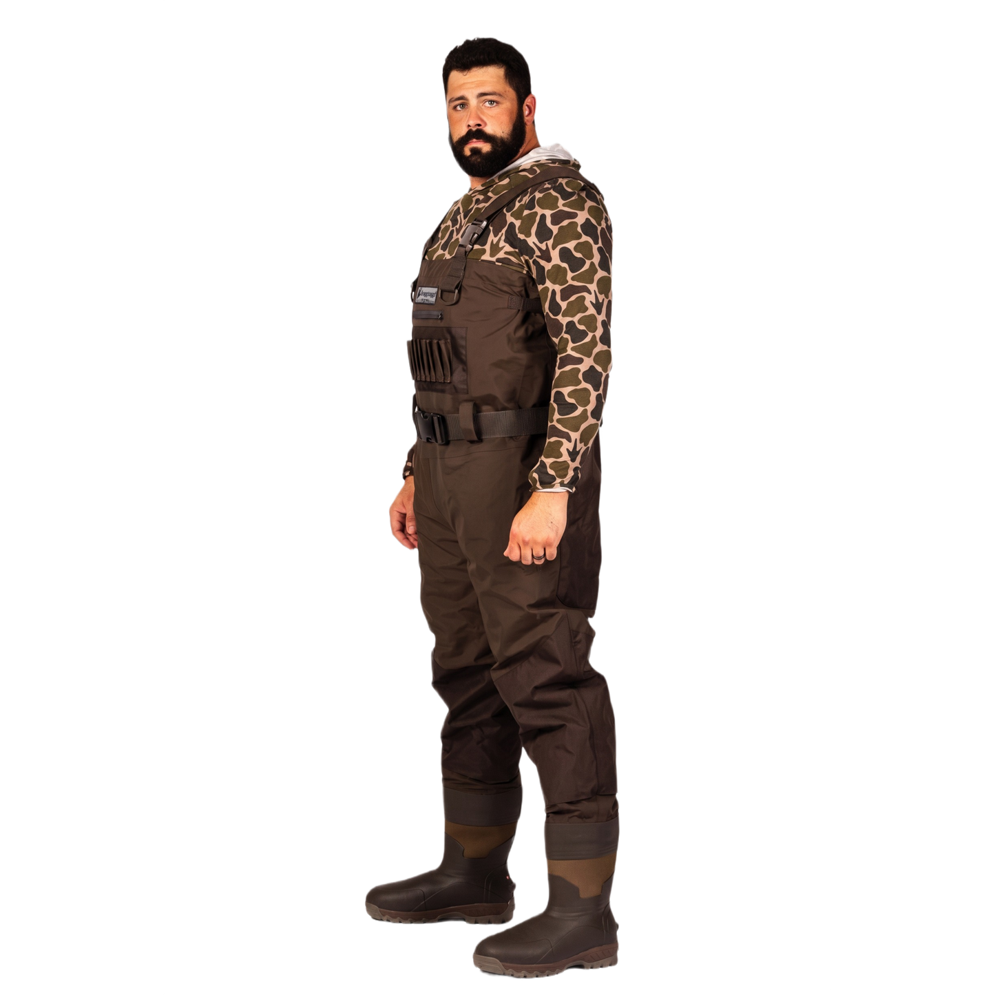 A man wearing a full-body brown wader with a camouflage long-sleeve shirt underneath and dark rubber boots, standing against a plain white background.
