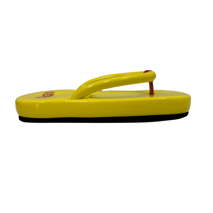 Yellow sandal with a black sole on a white background
