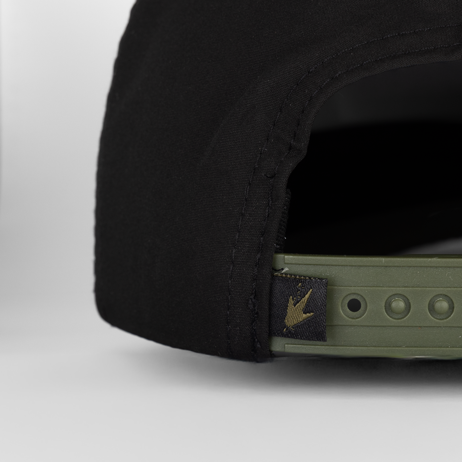 Close-up of a black cap with a brand logo on a white background