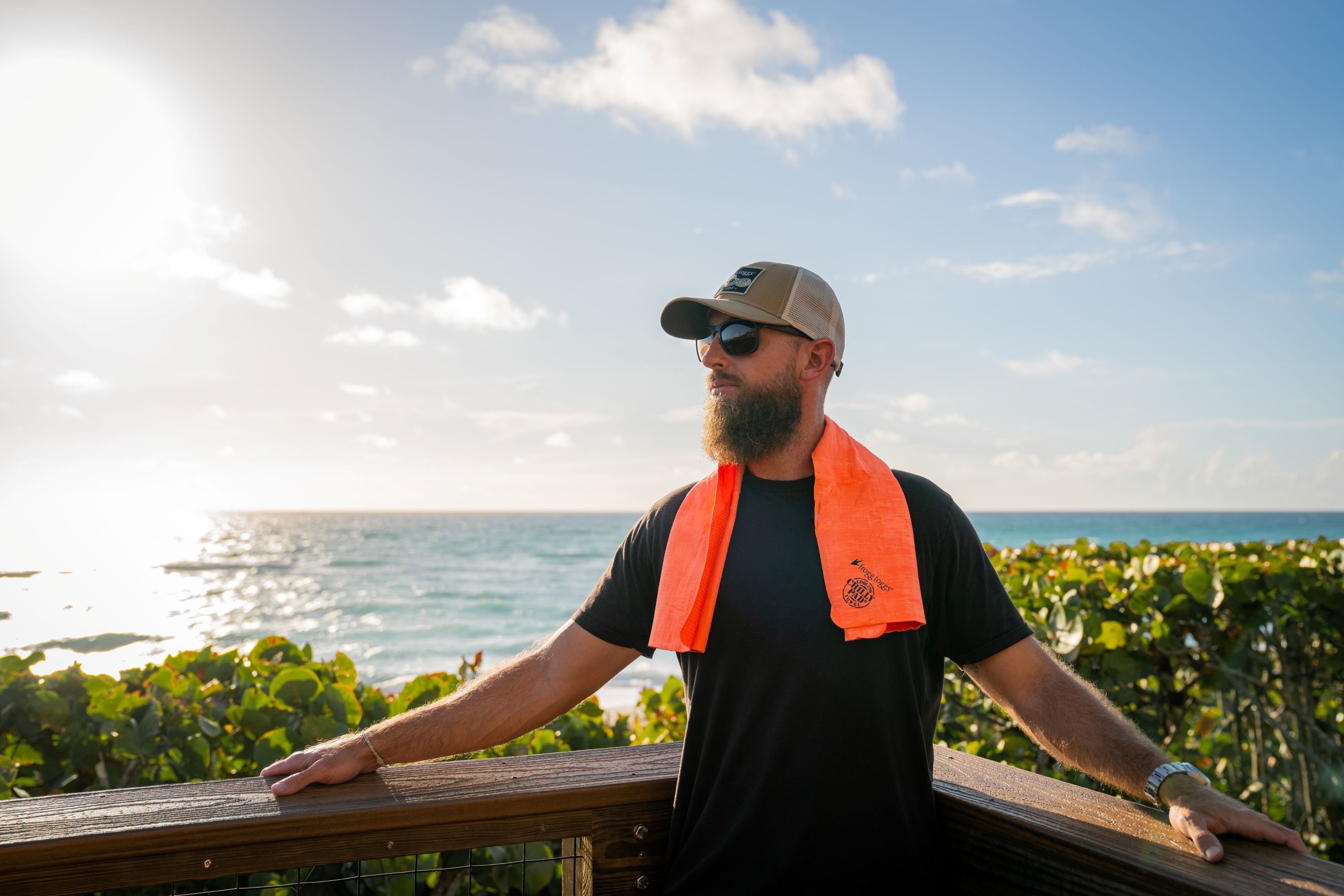 Man at beach with cooling towel around neck