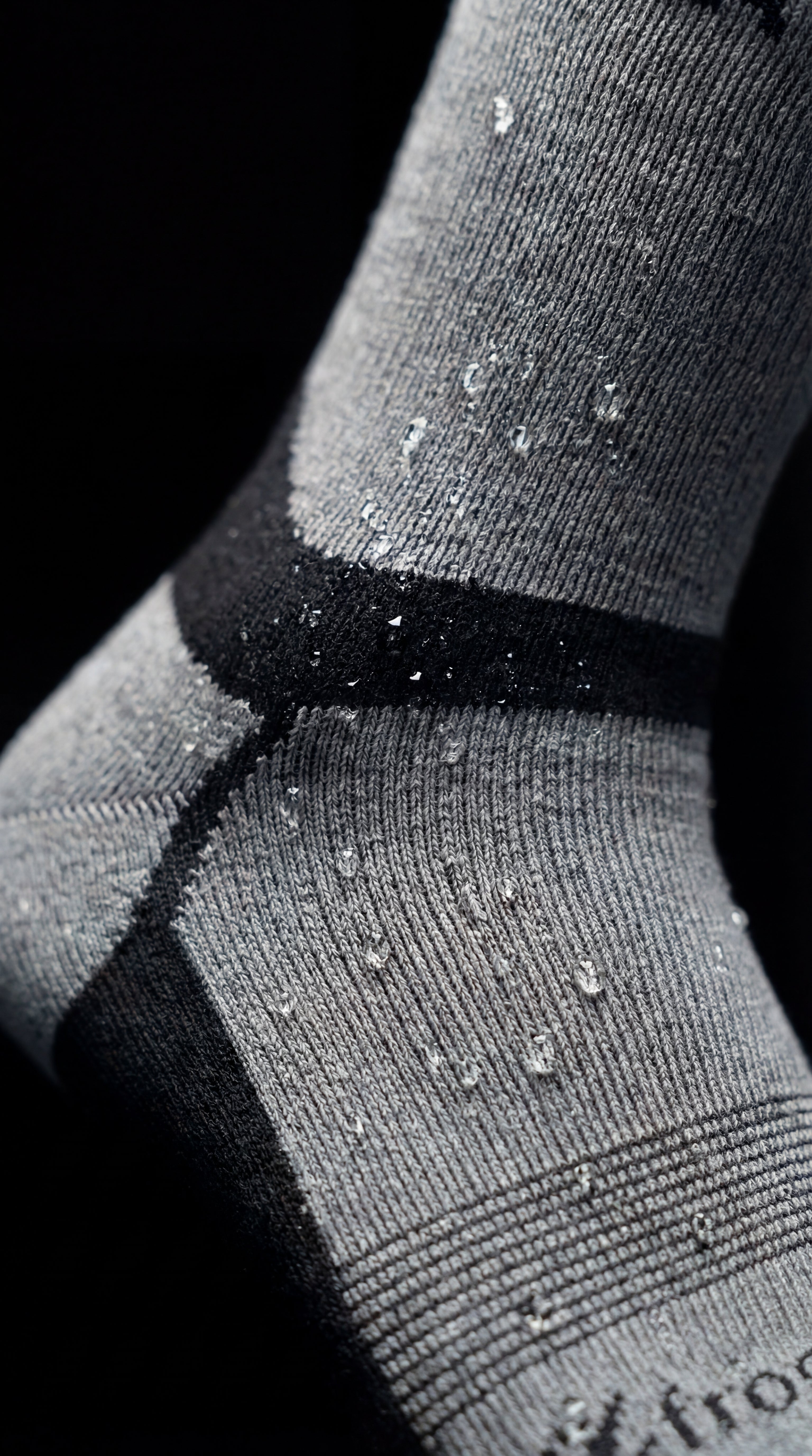 Close-up of gray socks with black accents on a dark background