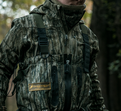 Person wearing a camouflage hunting jacket with a visible brand logo.