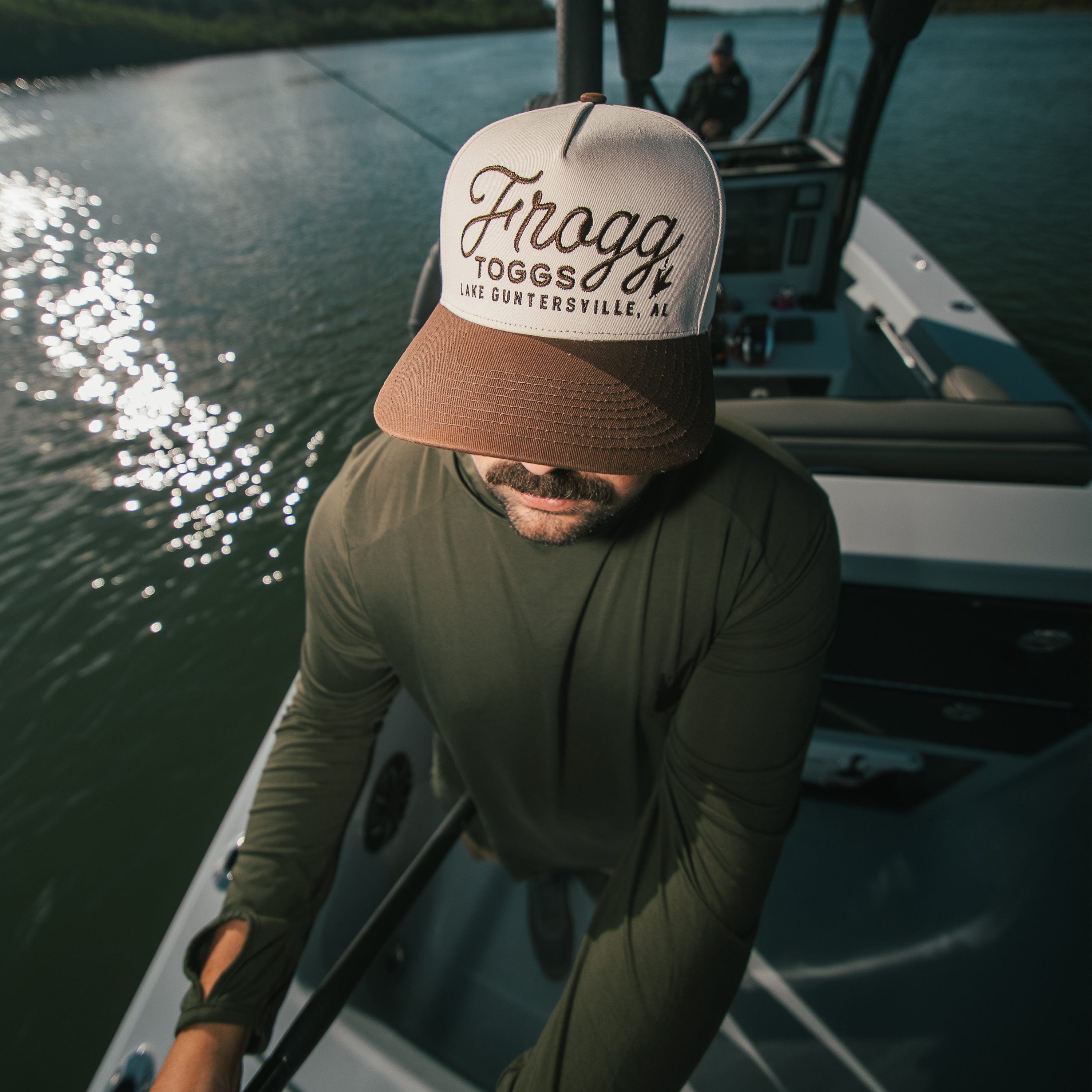 Guy on boat in frogg toggs brown and cream hat