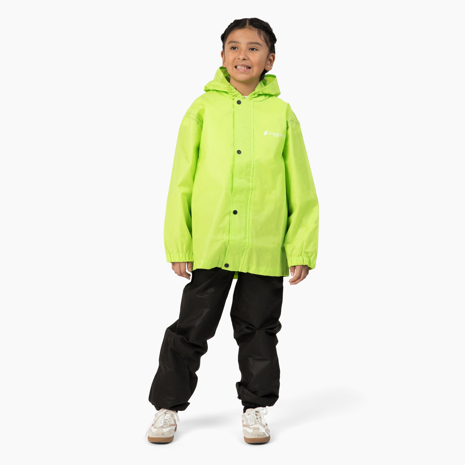 Child wearing a bright green raincoat and black pants on a white background