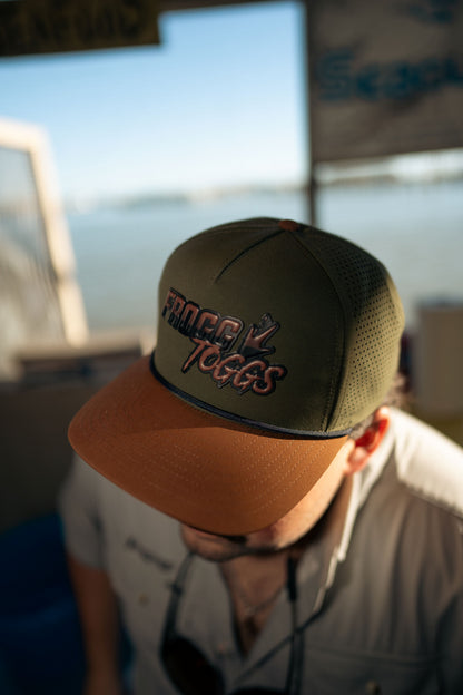 Person wearing a cap with Frogg toggs branding on a blurred background